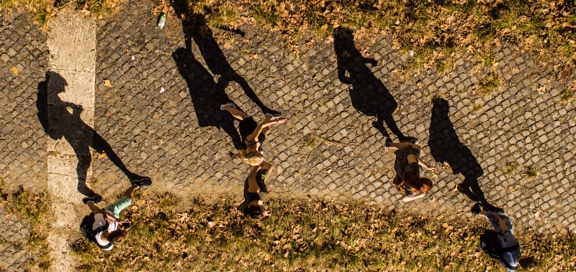 students walking on brick campus walkway shadows